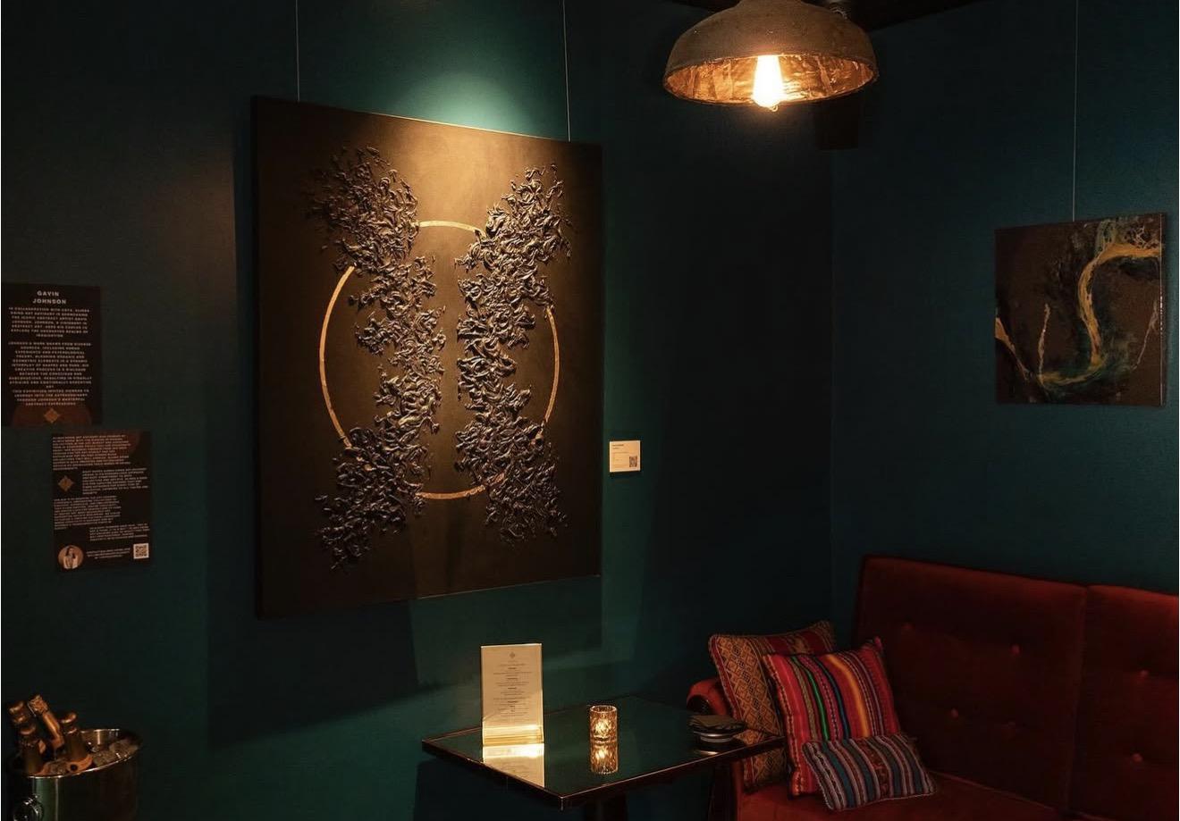Artworks on a dark green wall at the private view of Gavin Johnson’s exhibition at COYA City
