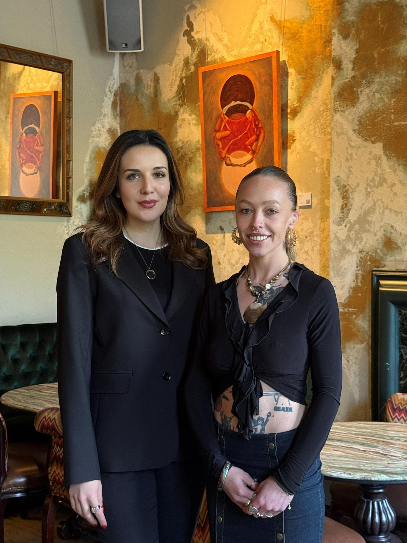 Two women standing together in front of paintings at COYA Mayfair