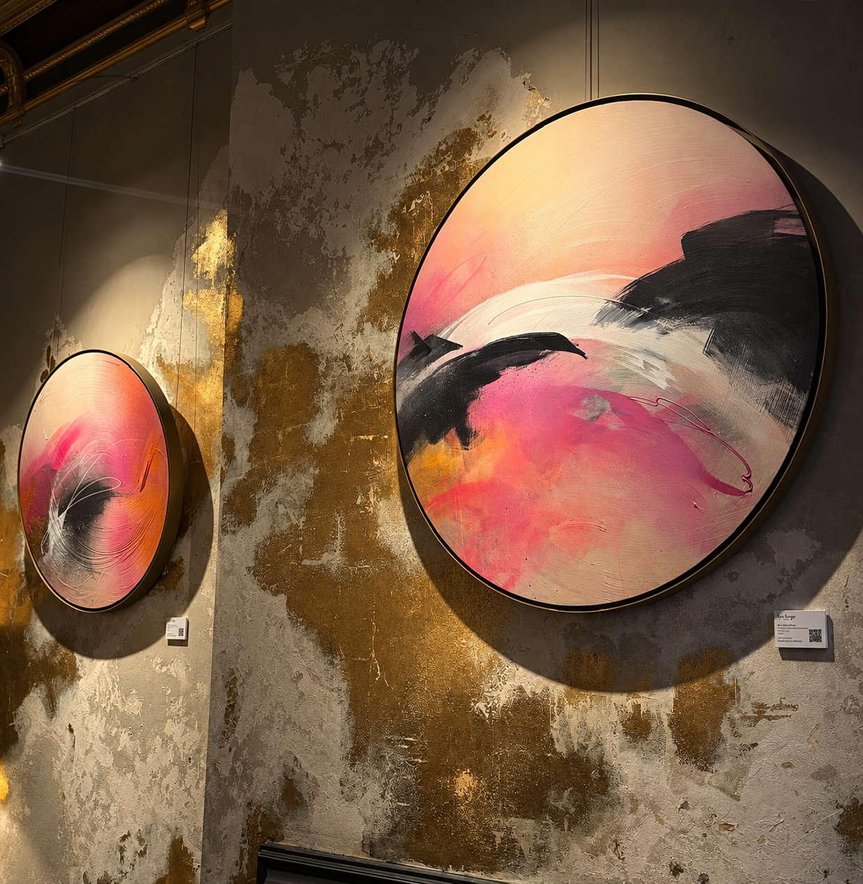 Two circular pink and gold abstract artworks on a gold-toned wall at COYA Mayfair