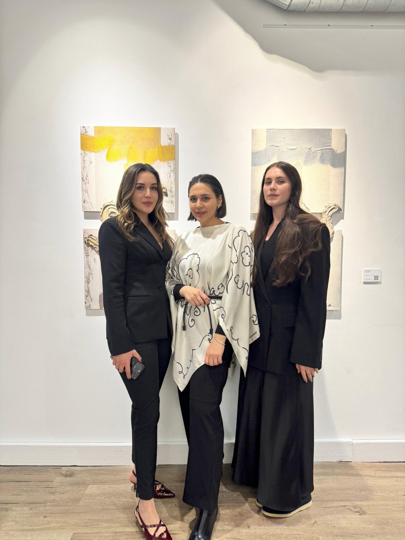 Three women posing together in the gallery at the International Women’s Day Exhibition, ST.ART Gallery, London
