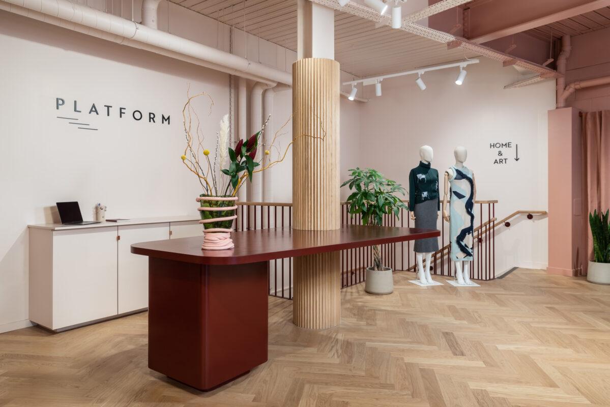 Interior of Platform Store in Marylebone with a curved red desk and clothing displays